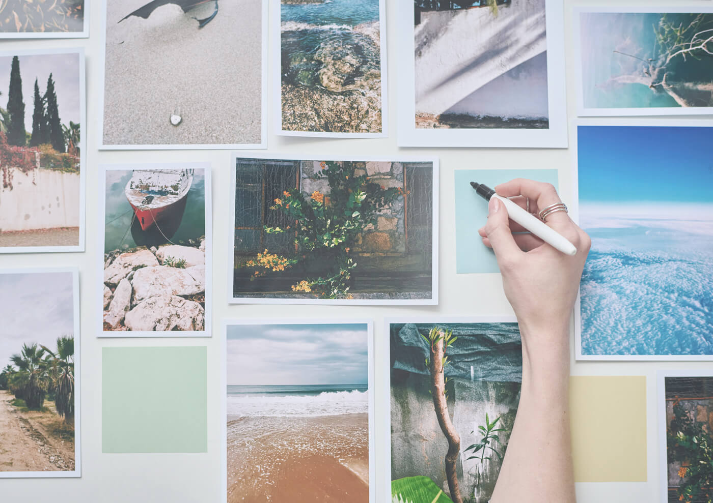 photographer creating a vision board with photos and notepaper on a wall